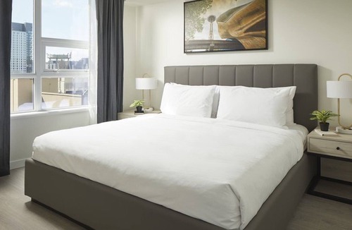 South Lake Union House | Level Seattle- Executive Two Bedroom Suite with separate office space, bedroom with king bed, full kitchen, living & dining area, private balcony, in-suite laundry, modern bathroom with Malin + Goetz amenities.