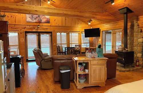 Pleasant Grove Cabin | Riverfront cabin with hot tub and amenities galore!