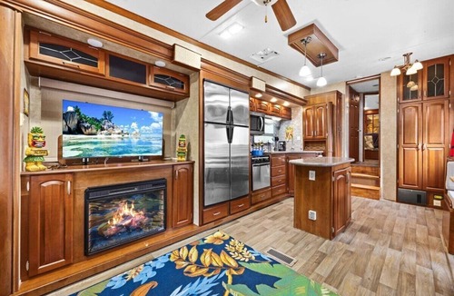 Milton RV Rental | THIS IS AN AWESOME 36' RENTAL CAMPER WITH AMAZING LONG DECK, PLUS A SECOND STEP-DOWN DECK TO YOUR OWN PRIVATE HIDEAWAY TIKI BAR! A BEAUTIFUL HUGE LIVE OAK COVERS THE ENTIRE LOT SO IT'S ALWAYS SHADED, AND THIS EVEN COMES WITH A TABLE & CHAIRS FOR OUT